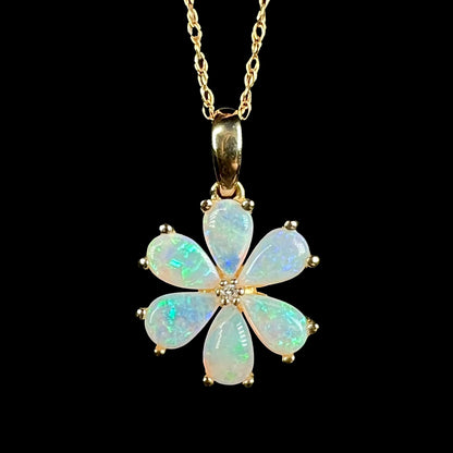 Close-up of 10k gold Australian opal and diamond flower pendant with blue flashes of color