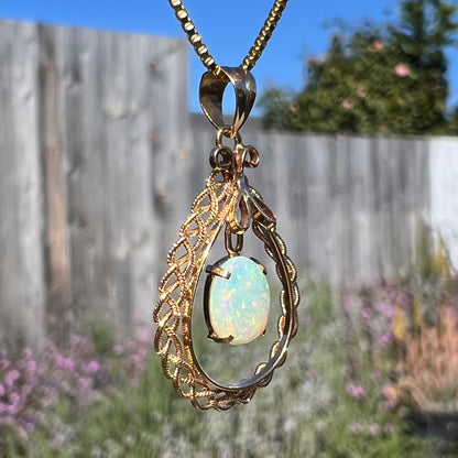 Macro shot of an 18k gold opal necklace in sunlight, with the filigree in focus and minimal opal color play.