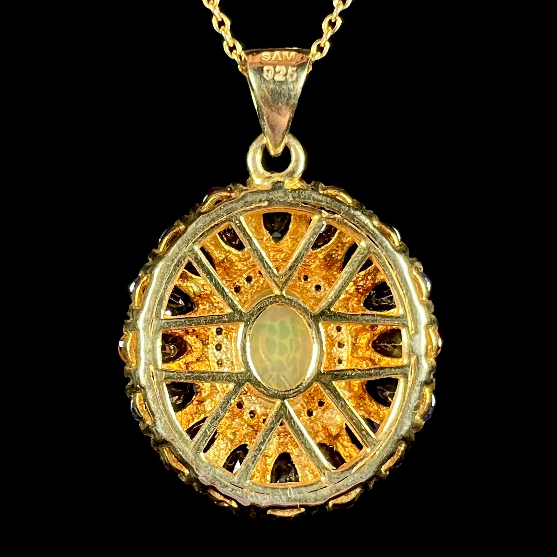 Back side of a gold plated sterling silver pendant shown against a black background.