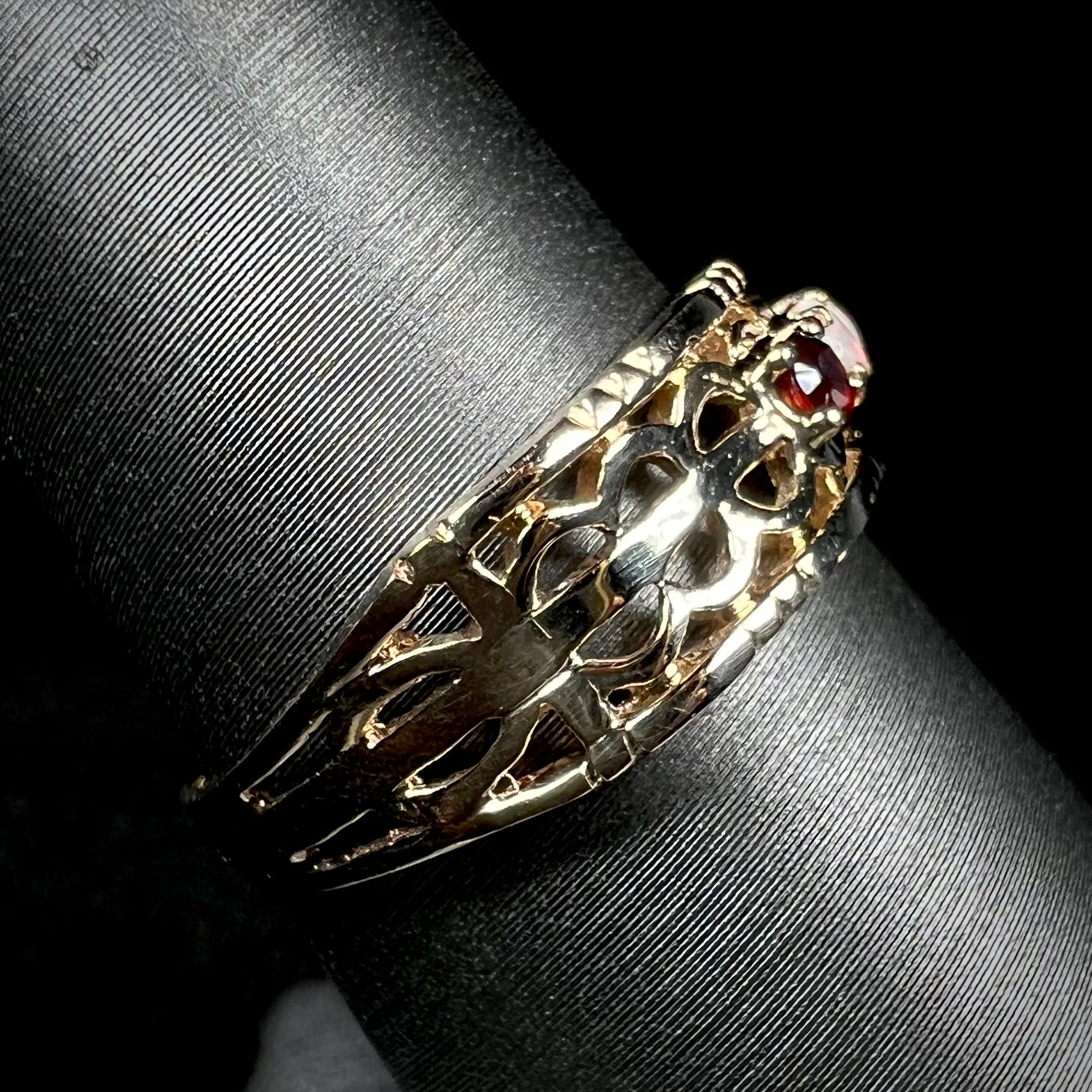 Side view of a gold band with an open, woven design.