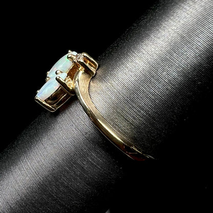 A ladies' gold ring mounted with two marquise cut opals and two diamond accents.