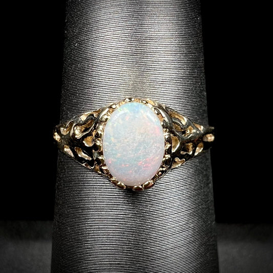 An organic-style yellow gold ring mounted with a natural Coober Pedy white opal.  The opal has pink colors.