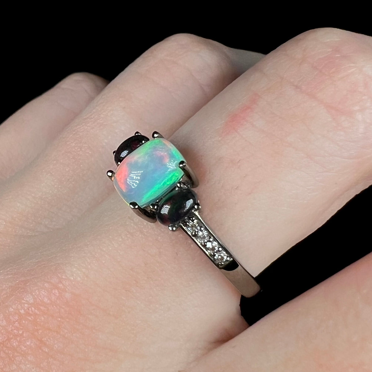 Gothic opal and CZ ring with black rhodium finish over sterling silver, worn on finger and shown from angle