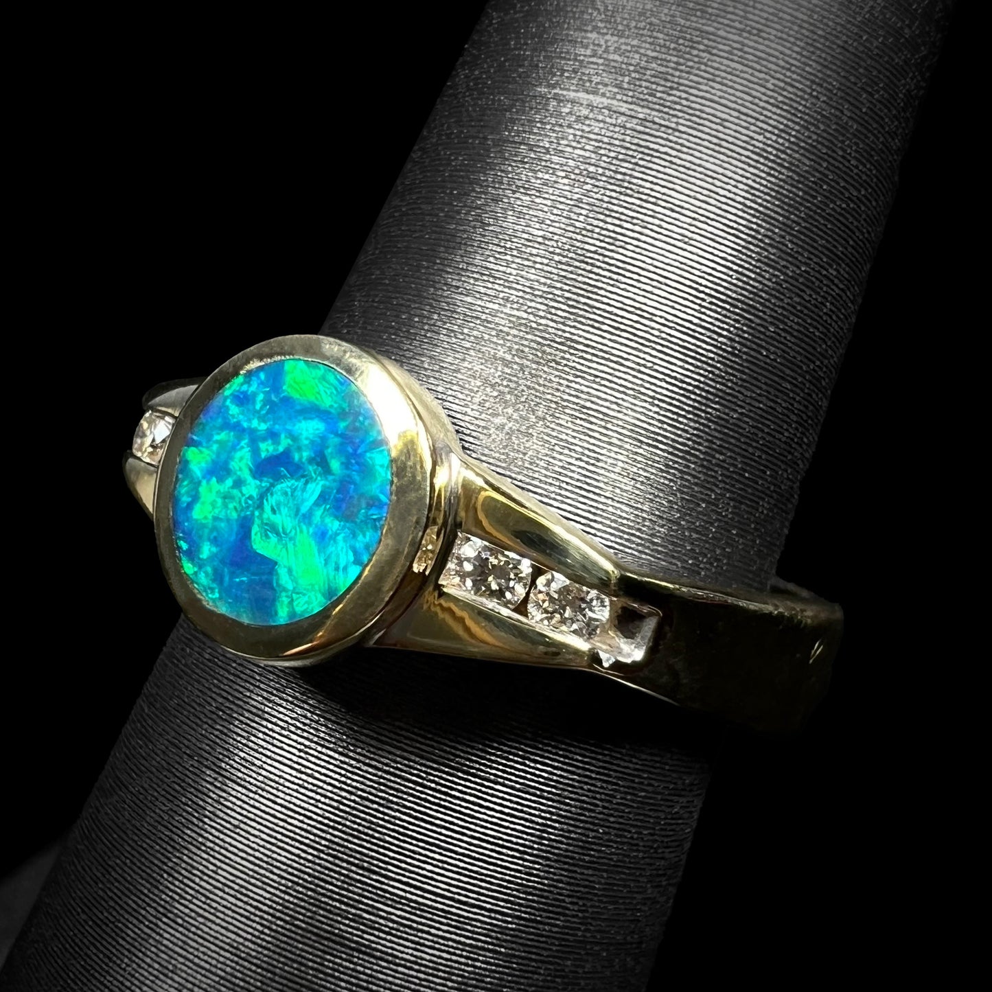 Green flashes of color play over the blue body of this Australian boulder opal and diamond ring by Luciano Bortone.