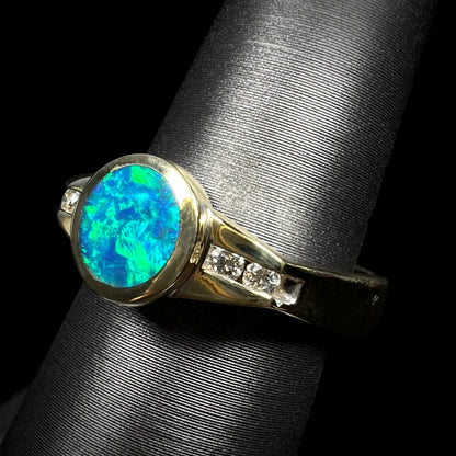 Green flashes of color play over the blue body of this Australian boulder opal and diamond ring by Luciano Bortone.