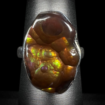 A sterling silver Mexican fire agate ring with green and purple iridescence shown from the front.