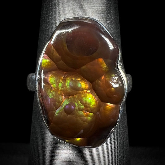 A sterling silver Mexican fire agate ring with green and purple iridescence shown from the front.