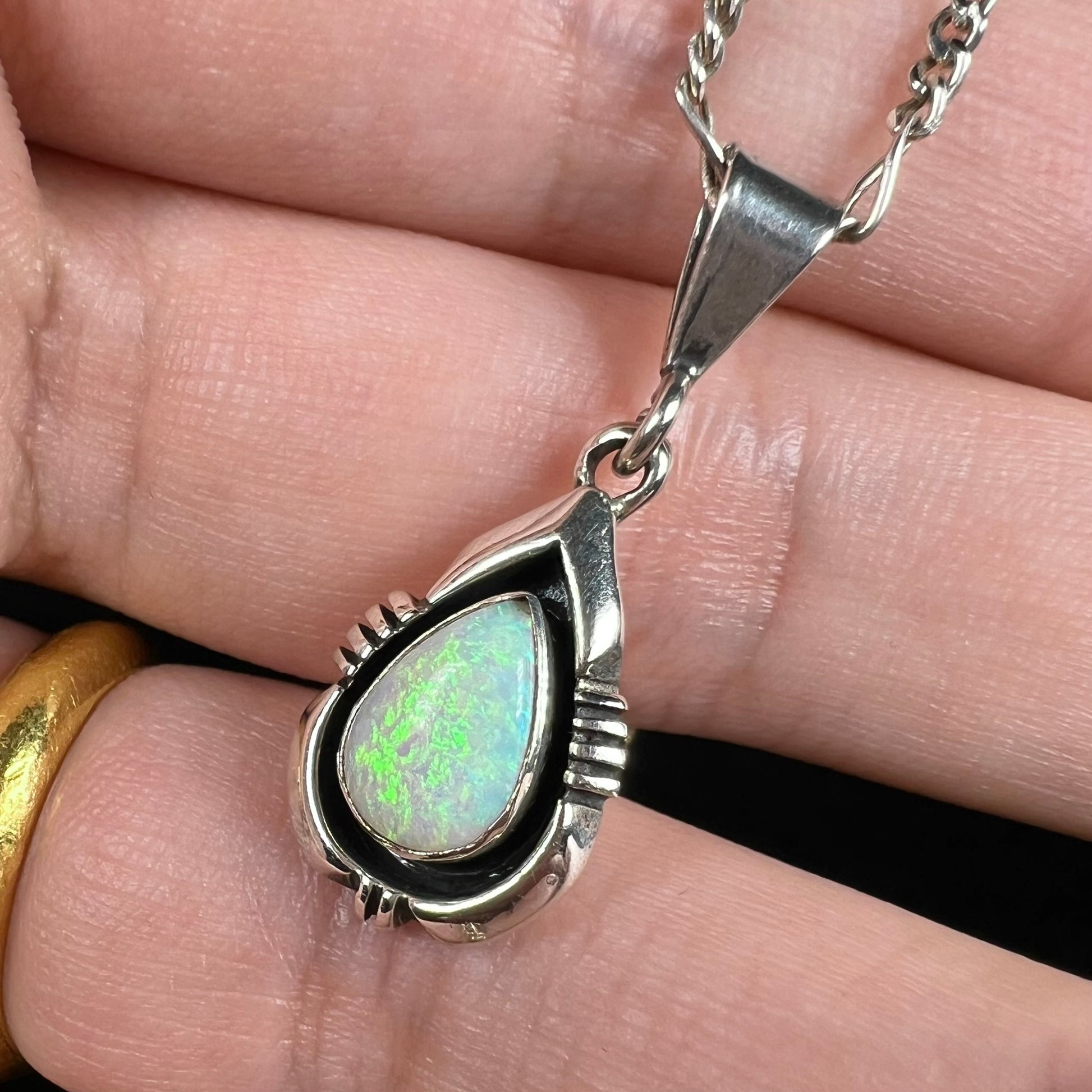 A pear shaped sterling silver Navajo pendant set with a green Australian opal made by artist, Chris Charley.