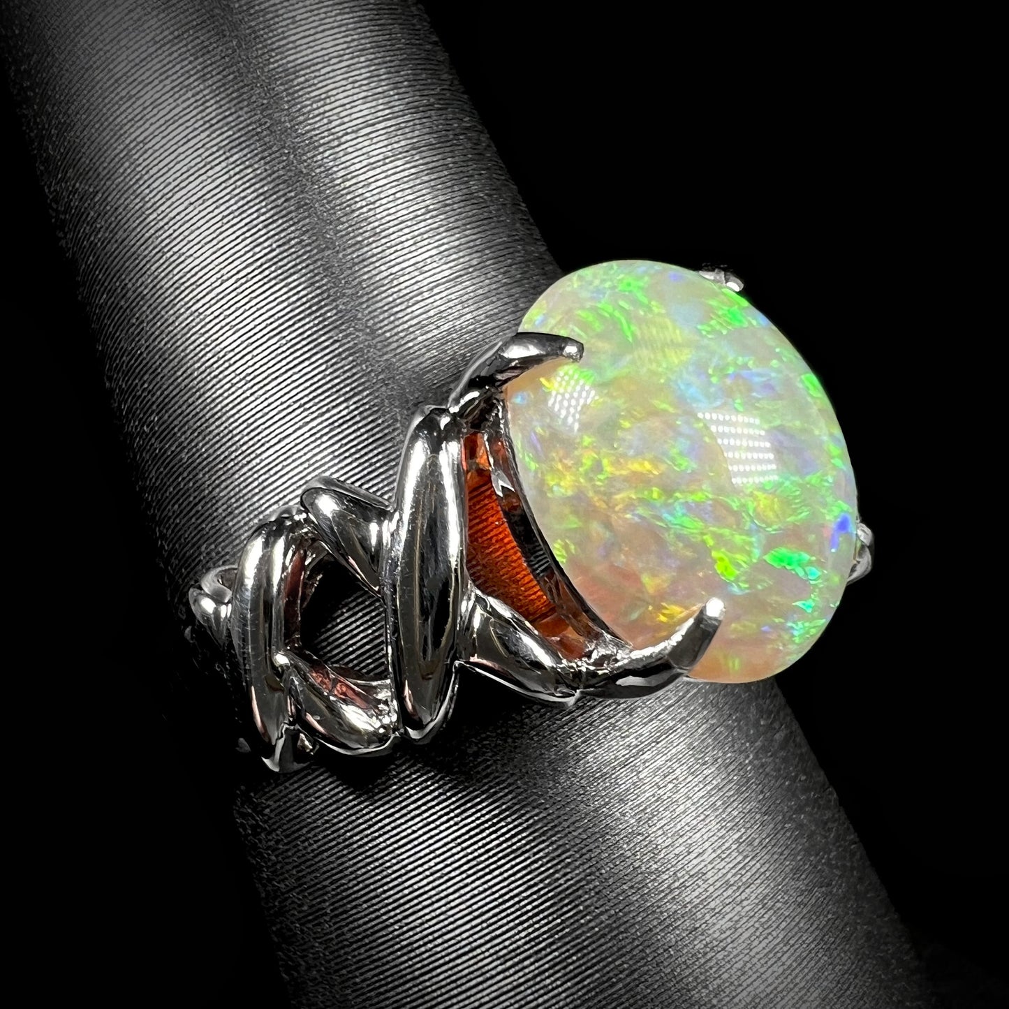 A platinum crisscross ring mounted with a green Coober Pedy opal.