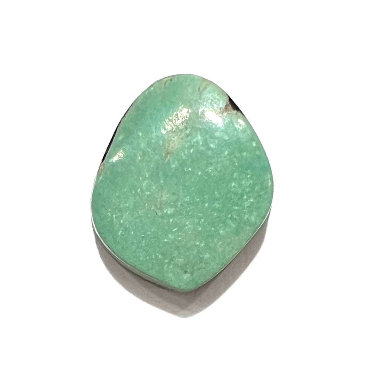 A backed, freeform cabochon cut dark green turquoise stone from Royston Mining District, Nevada.