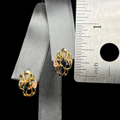 Half inch-long Black Hills gold marquise opal earrings on display next to ruler
