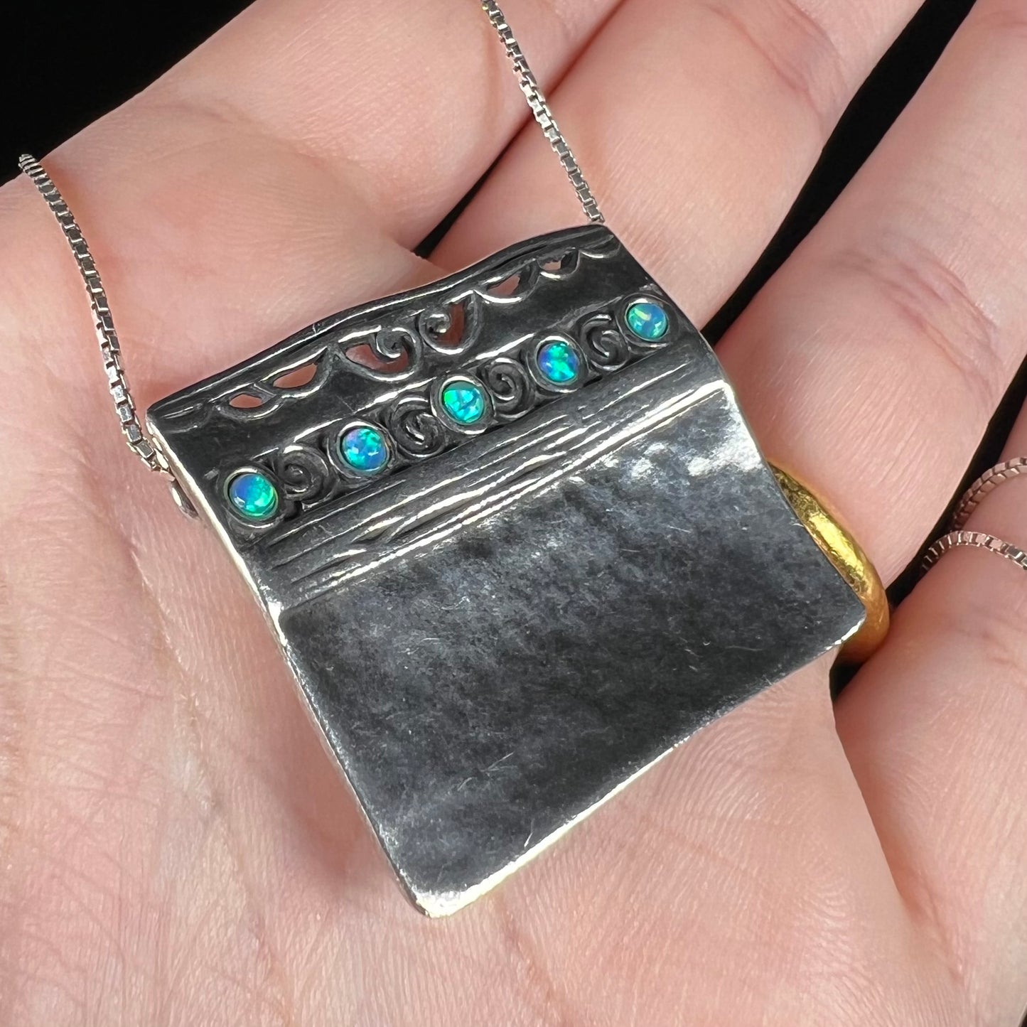 A handmade sterling silver five-stone opal necklace with a hammered finish by Israeli designer, Shablool Didae.