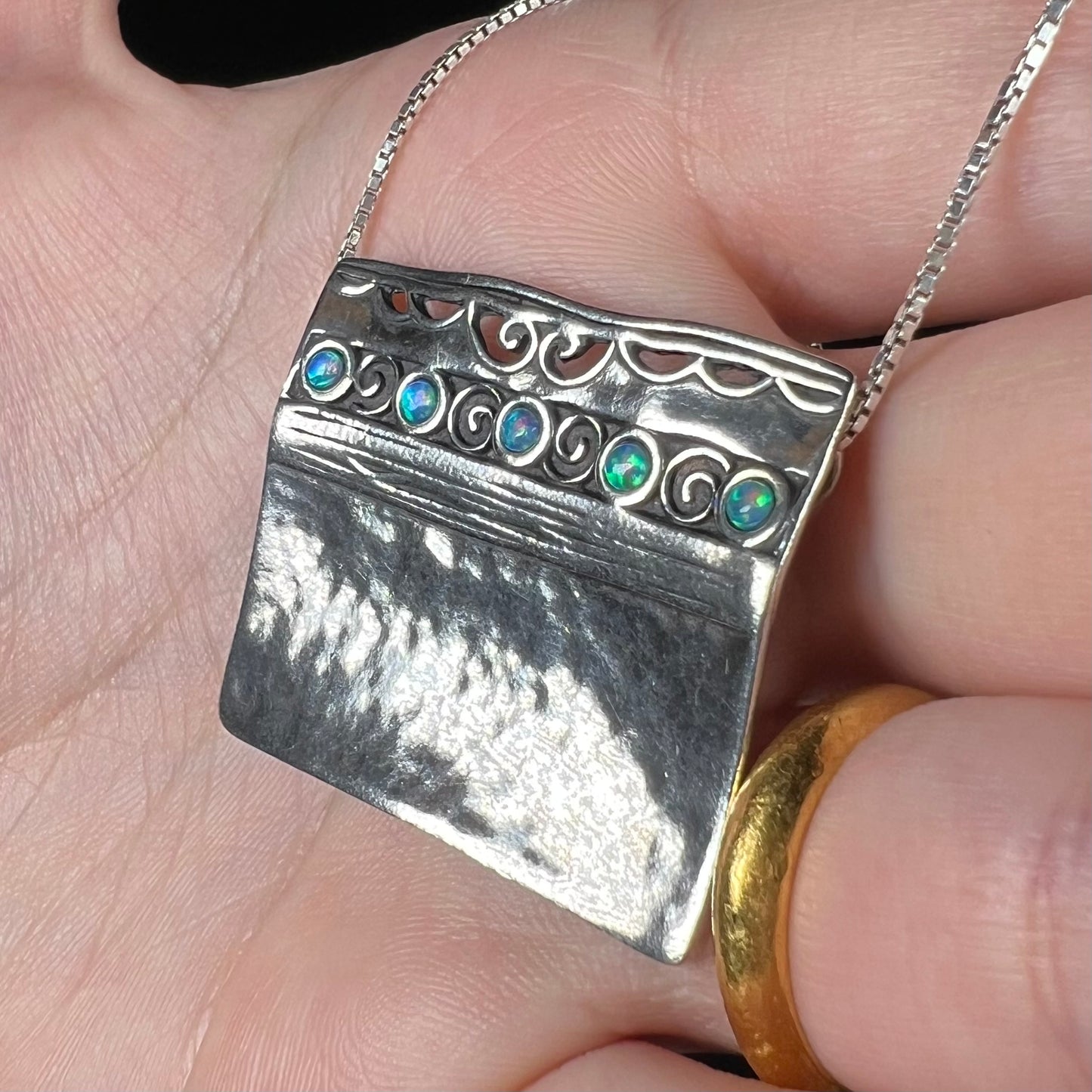 A handmade sterling silver five-stone opal necklace with a hammered finish by Israeli designer, Shablool Didae.
