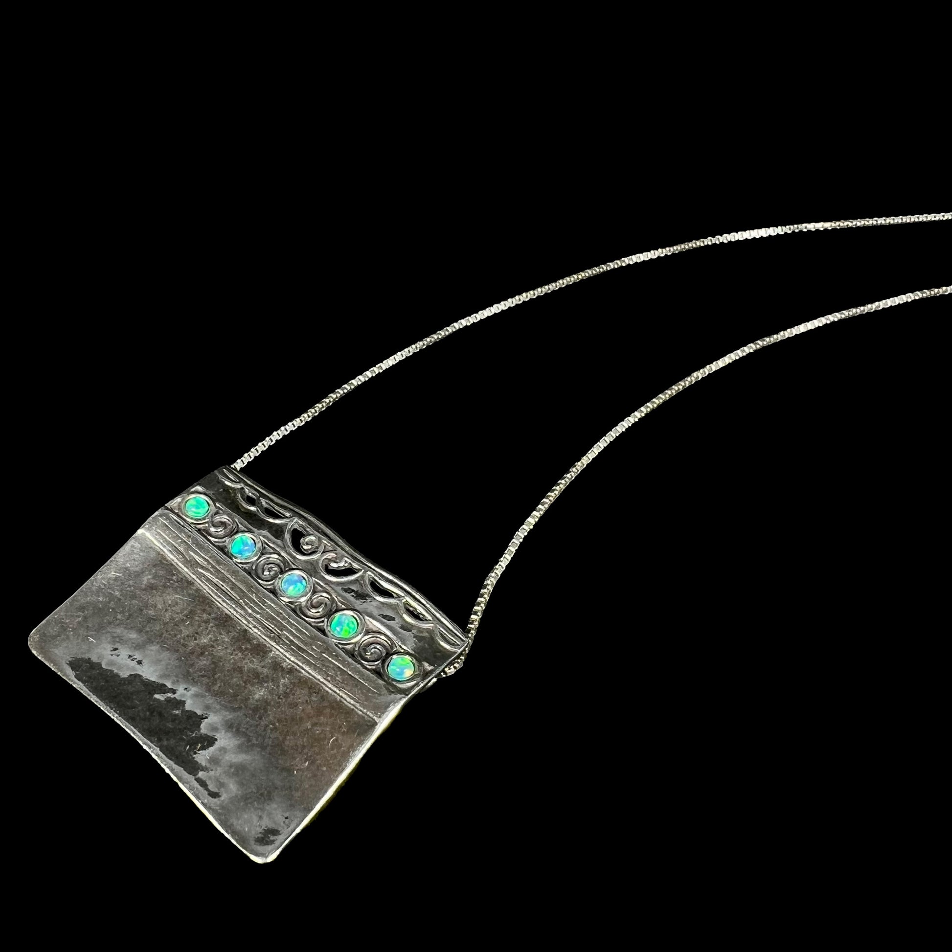 A handmade sterling silver five-stone opal necklace with a hammered finish by Israeli designer, Shablool Didae.