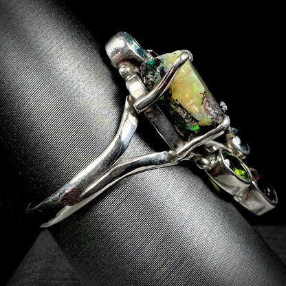 Side view of a handmade silver men's ring set with a rough Virgin Valley opal stone.
