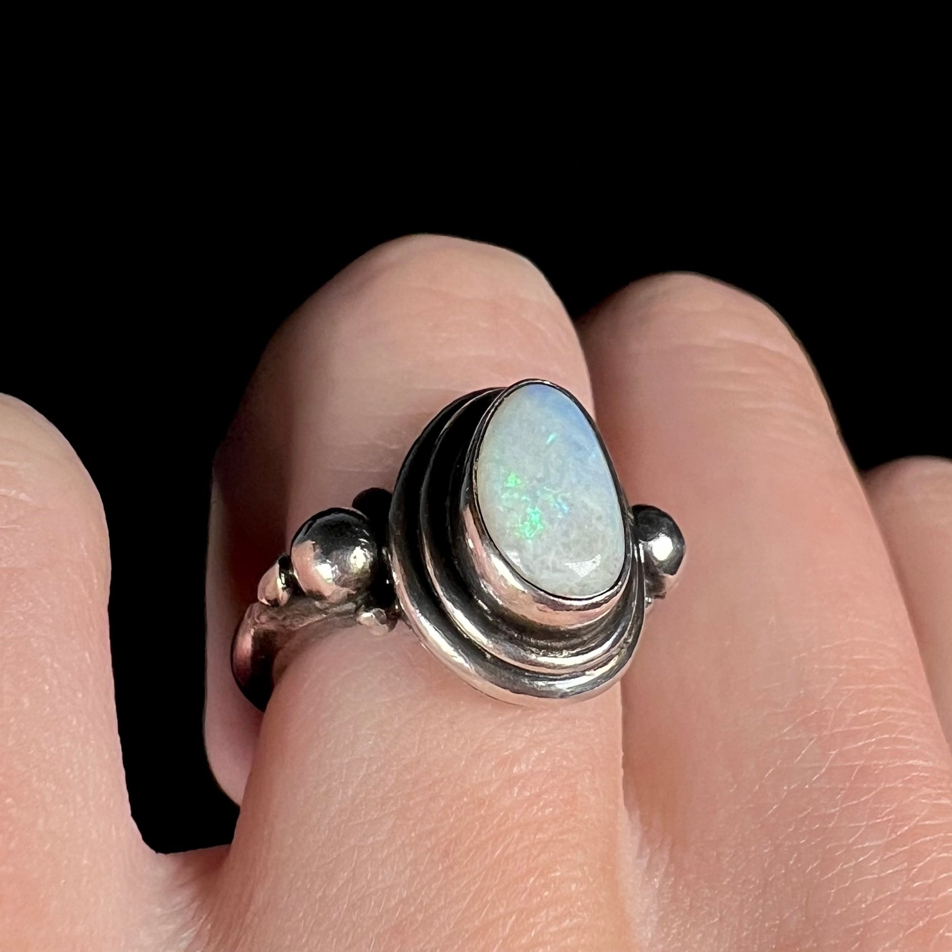 A handmade Boho-style sterling silver opal ring set with an Australian opal shown at an angle on a finger.