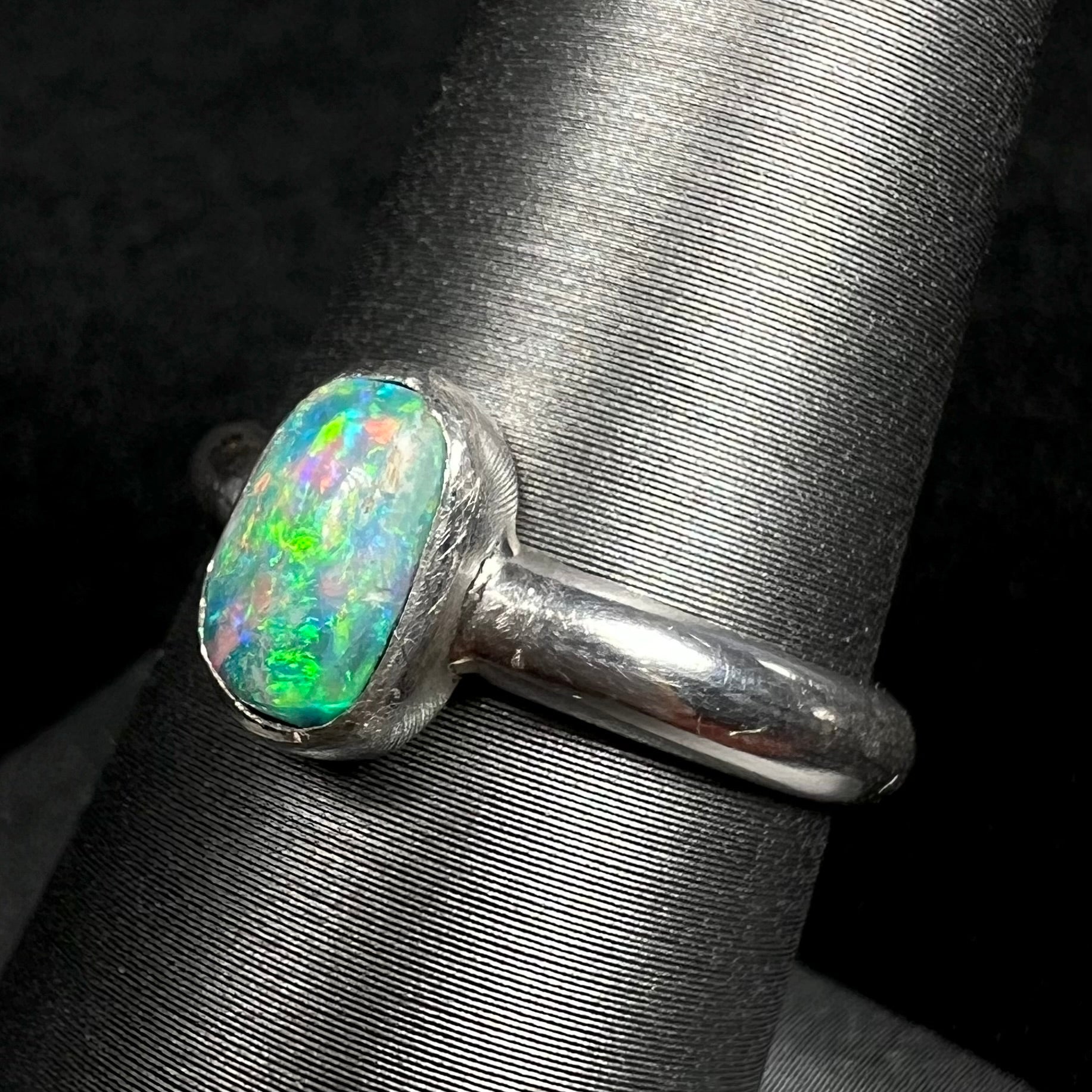 Green Australian opal in handmade silver ring, shown on ring display