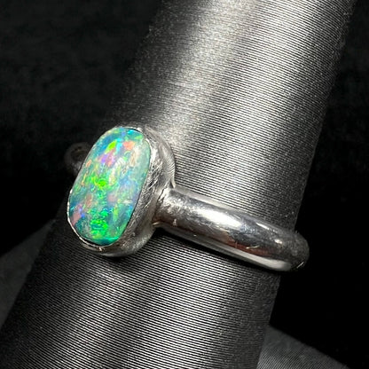 Green Australian opal in handmade silver ring, shown on ring display