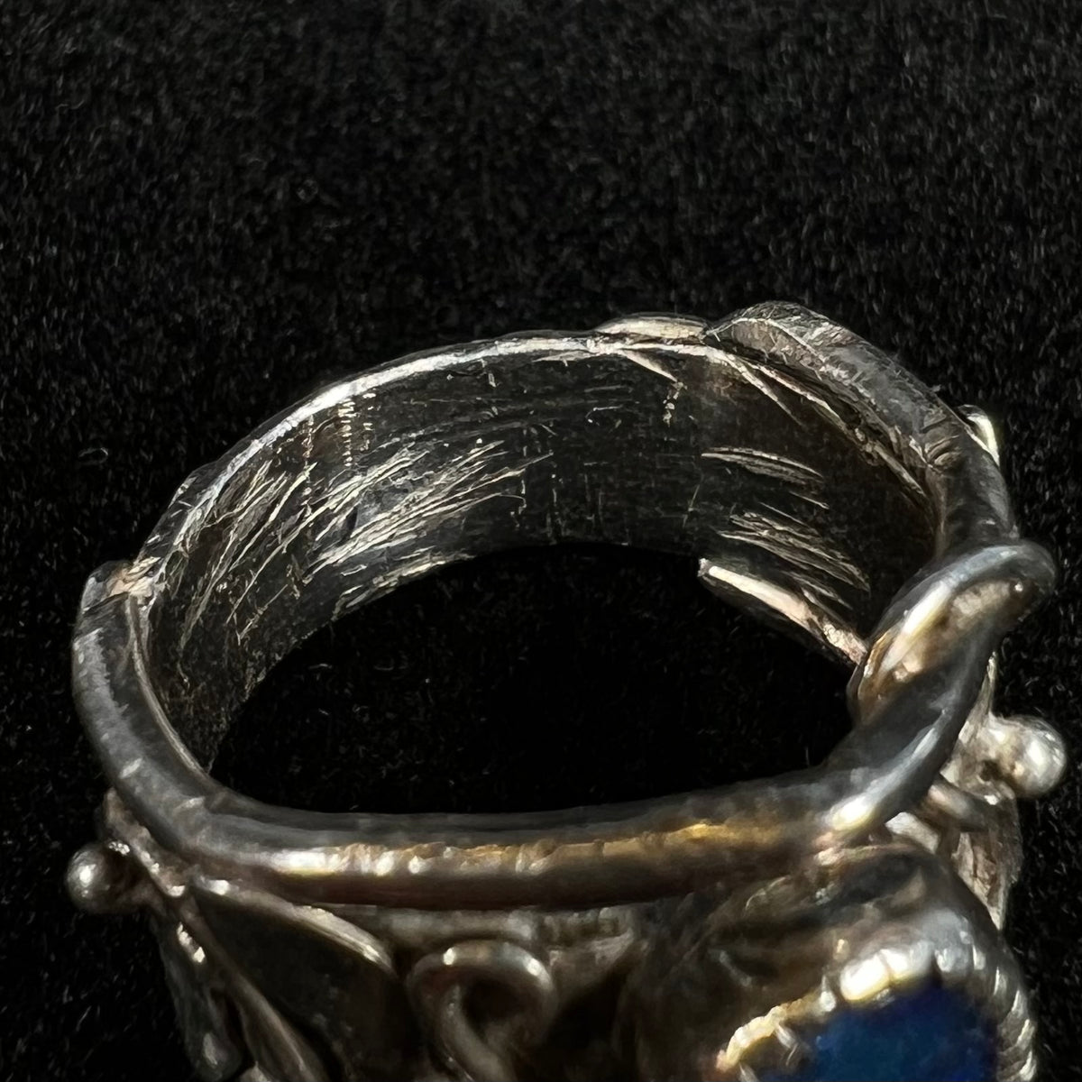 Close-up of scratches and file marks inside of handmade sterling silver ring's wide cigar-style shank