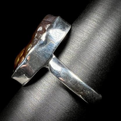 Side view of a sterling silver ring set with a Mexican fire agate stone.