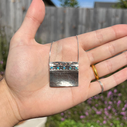 A handmade sterling silver five-stone opal necklace with a hammered finish by Israeli designer, Shablool Didae.