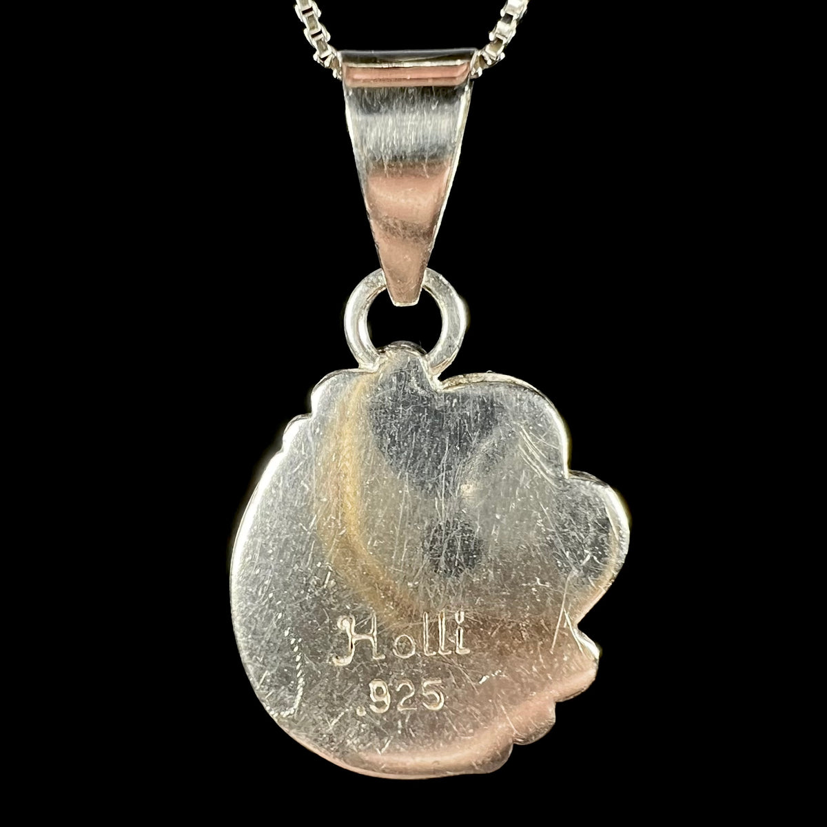 Back side of handmade sterling silver pendant showing hallmark stamps "Holli" and ".925".