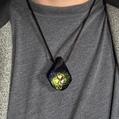 Close-up of an opal in glass necklace with a hexagram star design, worn around a person's neck against dark shirt.