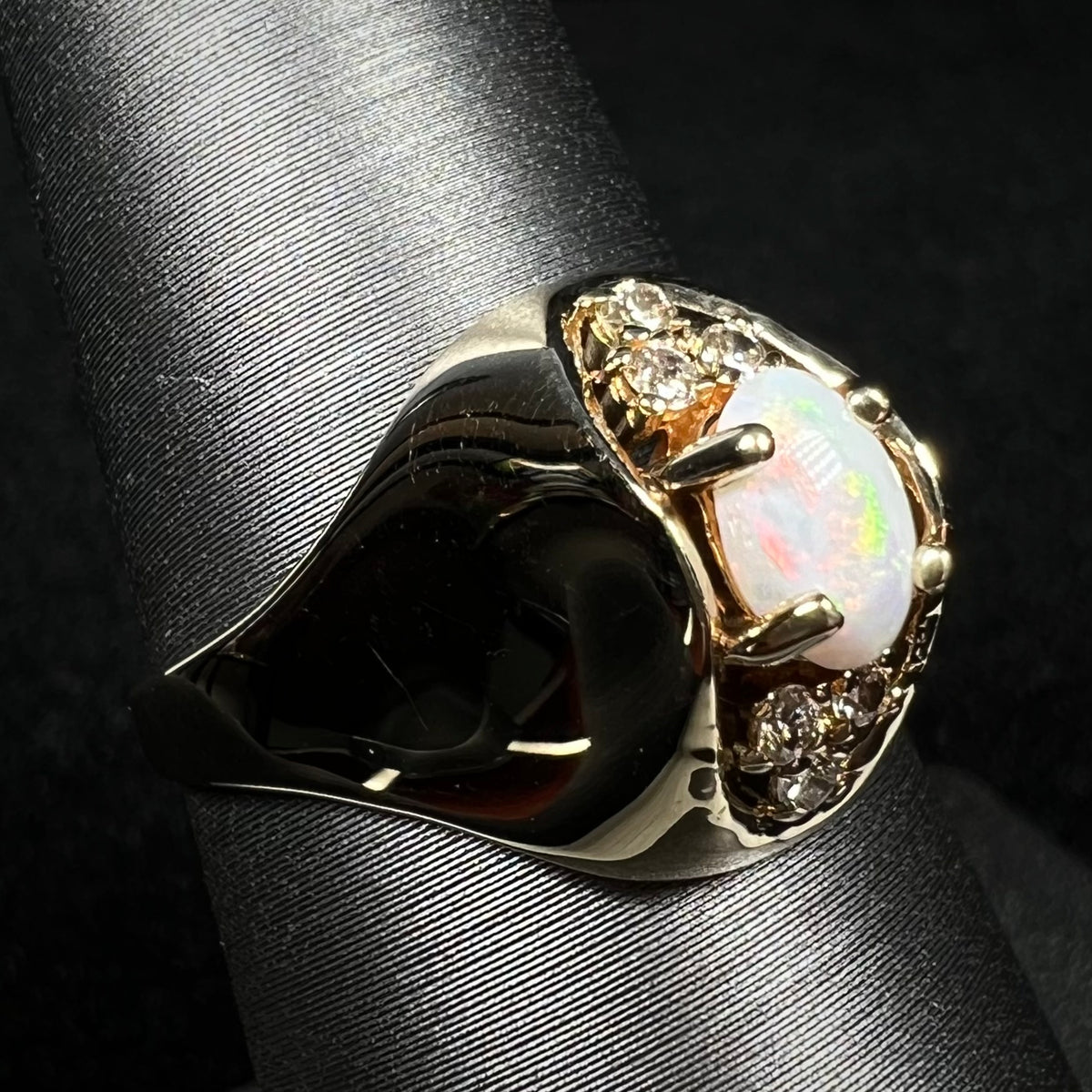 Vintage Australian opal and diamond ring with high-profile domed 14k gold design, shown from angled view on ring display