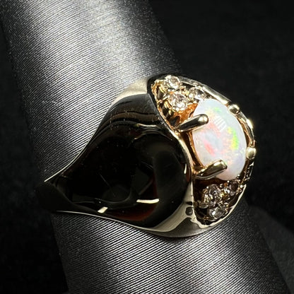 Vintage Australian opal and diamond ring with high-profile domed 14k gold design, shown from angled view on ring display