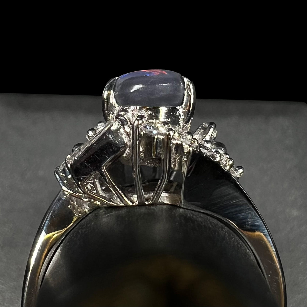 Gallery view of a high-profile Japanese platinum ring prong-set with opal and diamonds, shown on ring display.