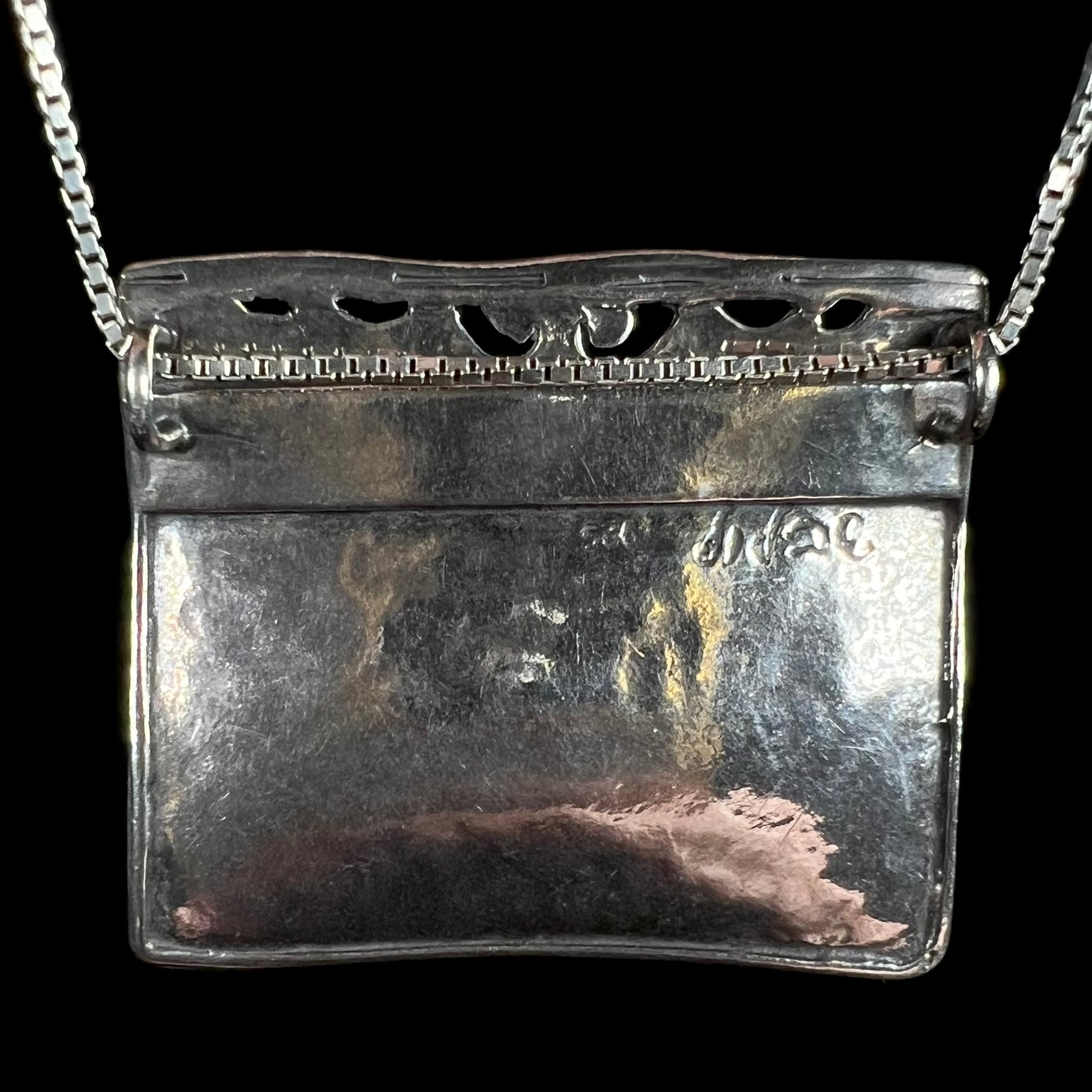 Back side of an Israeli-made sterling silver pendant signed, "didae".