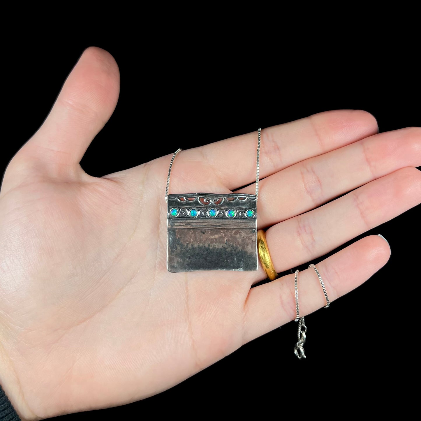 A handmade sterling silver five-stone opal necklace with a hammered finish by Israeli designer, Shablool Didae.