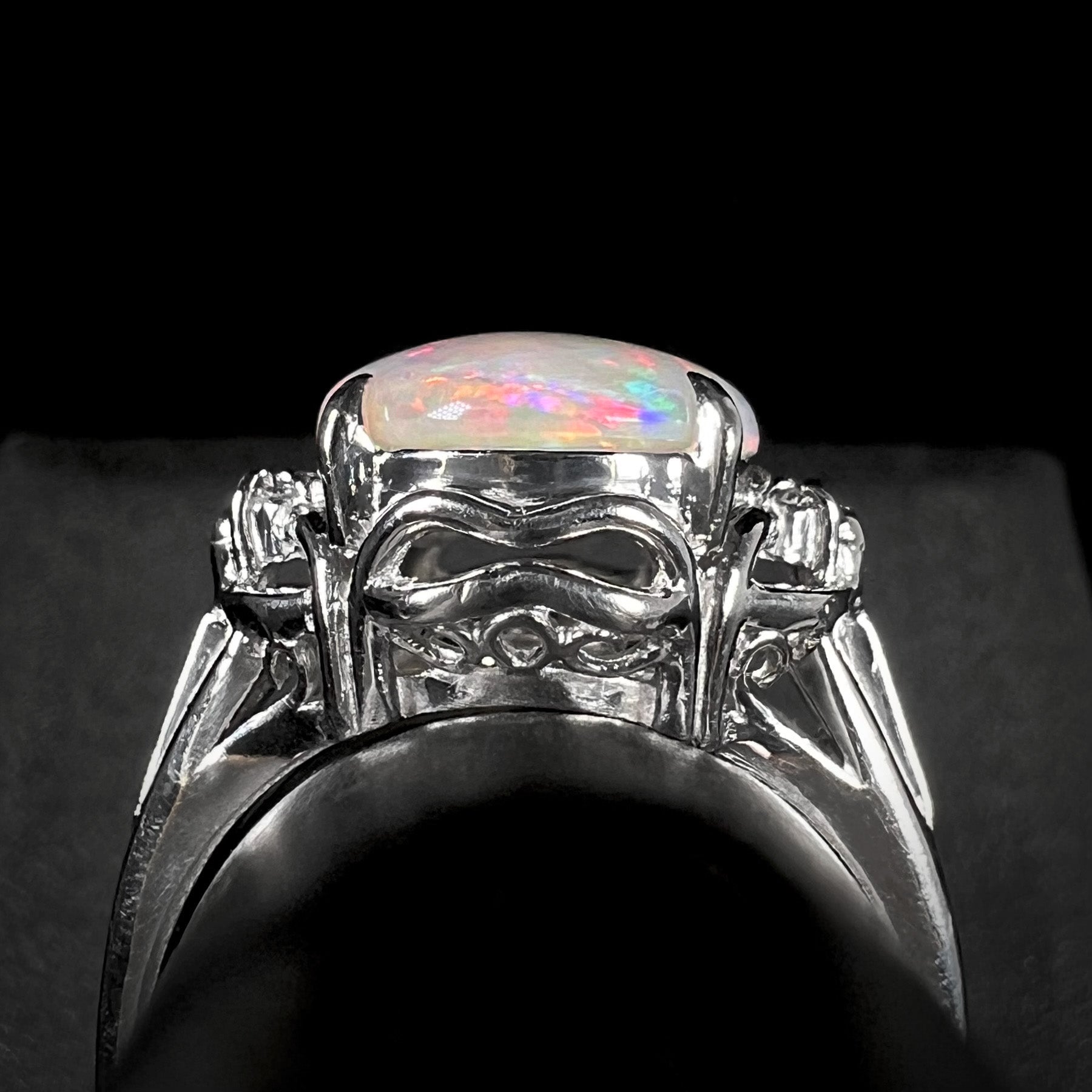 Gallery view of a Japanese-made platinum opal ring.  The gallery features a decorative open design with filigree.