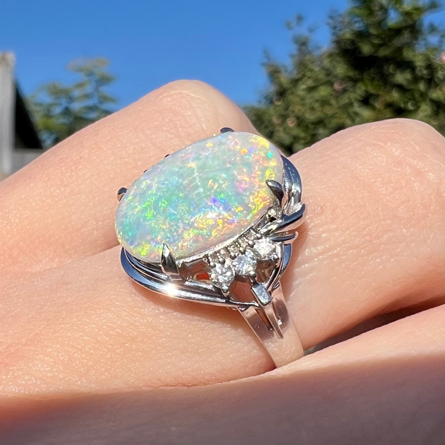 A Japanese platinum ring set with a 2.54ct Coober Pedy semi-crystal opal and diamond accents.