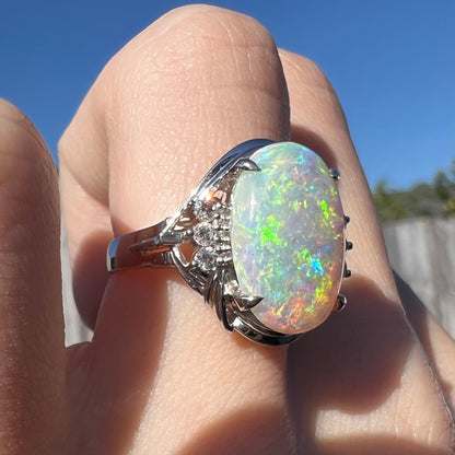 A Japanese platinum ring set with a 2.54ct Coober Pedy semi-crystal opal and diamond accents.