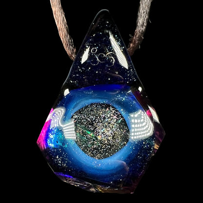 The back side of a purple glass pendant signed "jes" by artist, Jes Durfee, shown against a black backdrop.