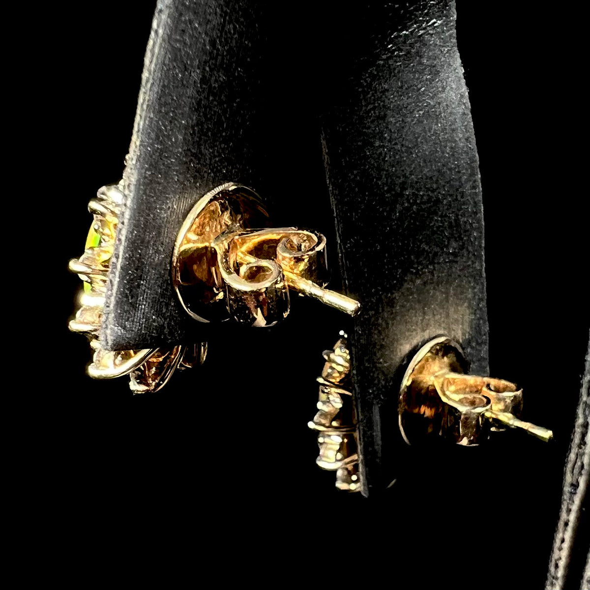 Back side of 14k gold stud earrings on earring display showing jumbo push-backs on posts.