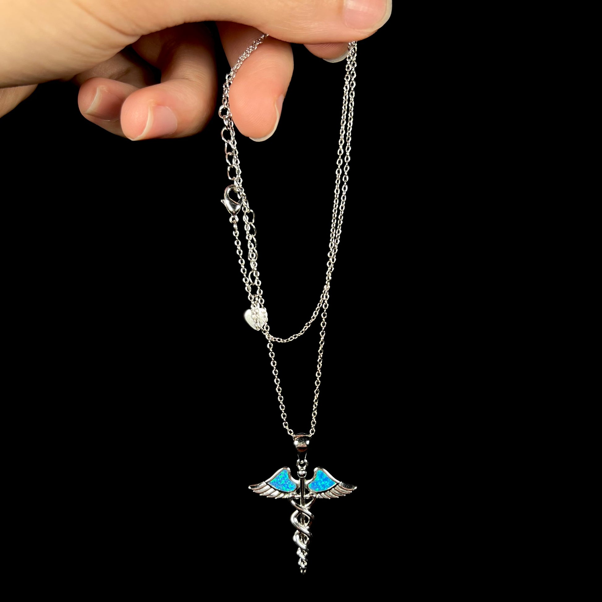 A silver plated medical caduceus necklace with blue lab-created opal inlay.