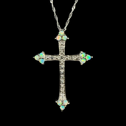 A silver lab-created opal cross necklace with CZ accents shown from the front against a black background.