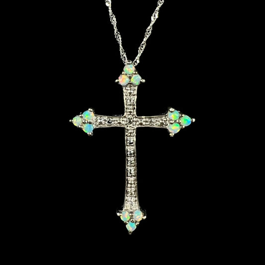 A silver lab-created opal cross necklace with CZ accents shown from the front against a black background.