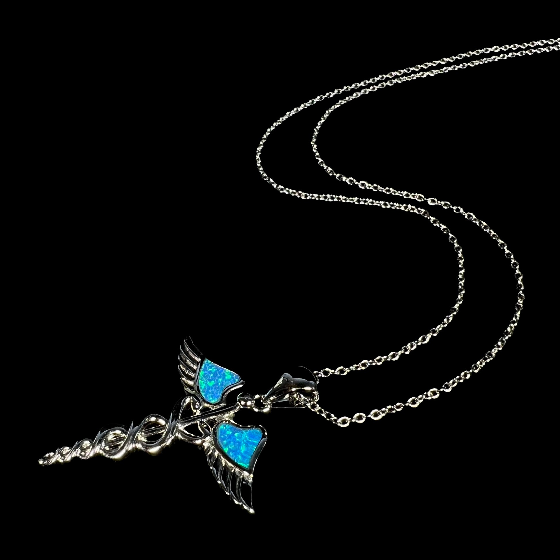 A silver plated medical caduceus necklace with blue lab-created opal inlay.