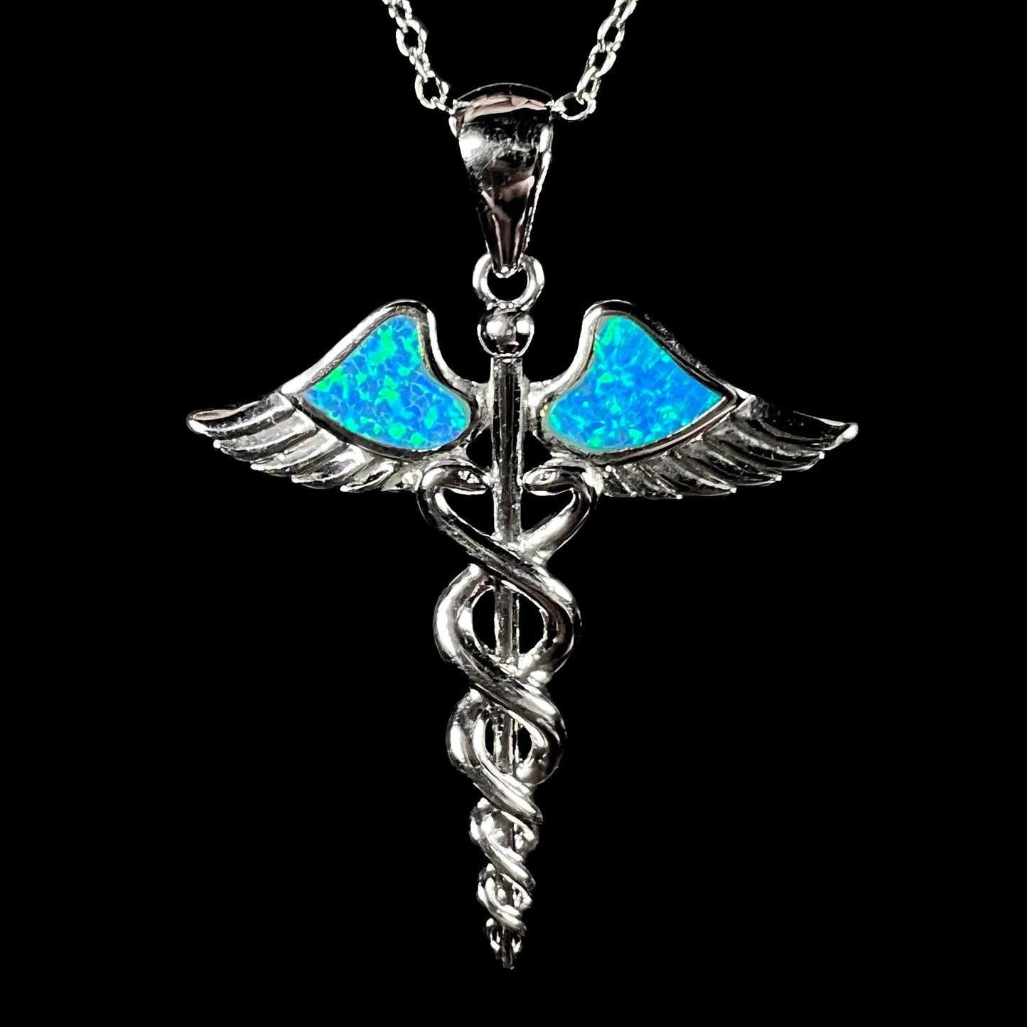 A silver plated medical caduceus pendant with blue lab-created opal inlay.
