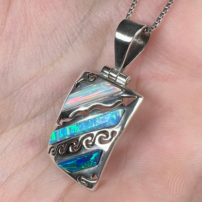 A men's 950 silver lab-created opal necklace, shown at a close-up angle in a hand.