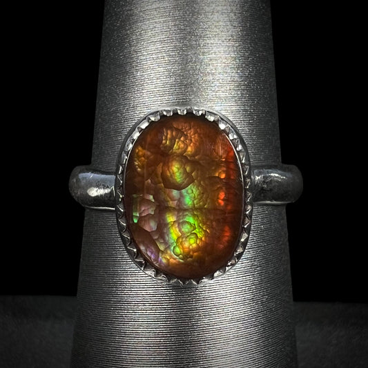 A ladies' sterling silver fire agate solitaire ring with green color, shown from the front view.