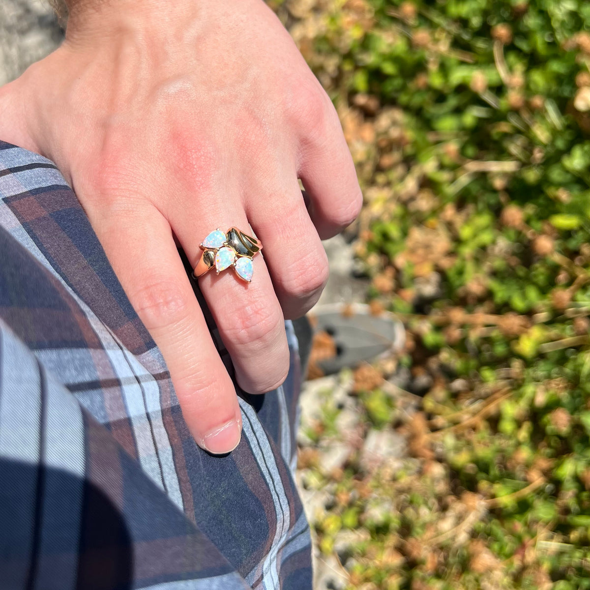 Hand wearing ladies' Modernist-style 14k gold opal ring in sunlight as it rests on the model's hip.