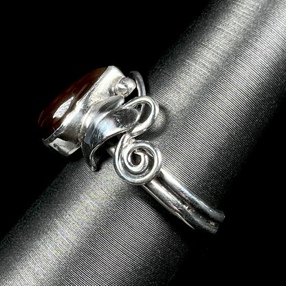 Side view of a ladies' silver fire agate ring with a vine and leaf design.