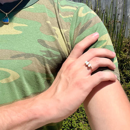 A vintage yellow gold ring mounted with three oval cut white Australian opals.