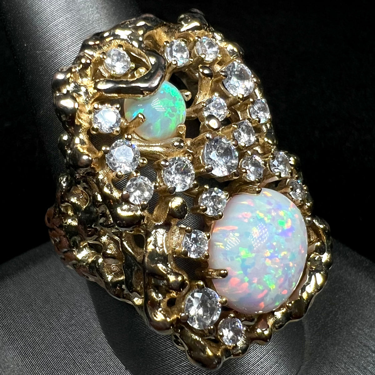 A large ring set with multicolor lab-created opals and CZs, shown close-up from angle on ring display.