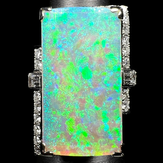 Large rectangular Australian light opal and diamond cocktail ring in vintage Japanese platinum, with vivid green-dominant play-of-color across the 11.46ct center stone under LED studio light.