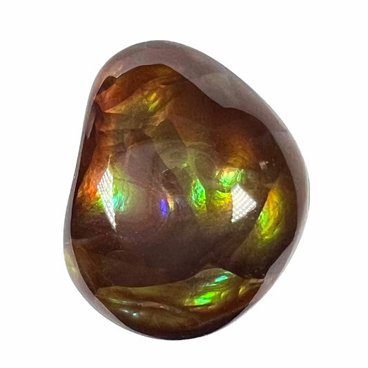 A large, round freeform shaped Mexican fire agate stone.  The stone has green, orange, purple, and blue iridescence.